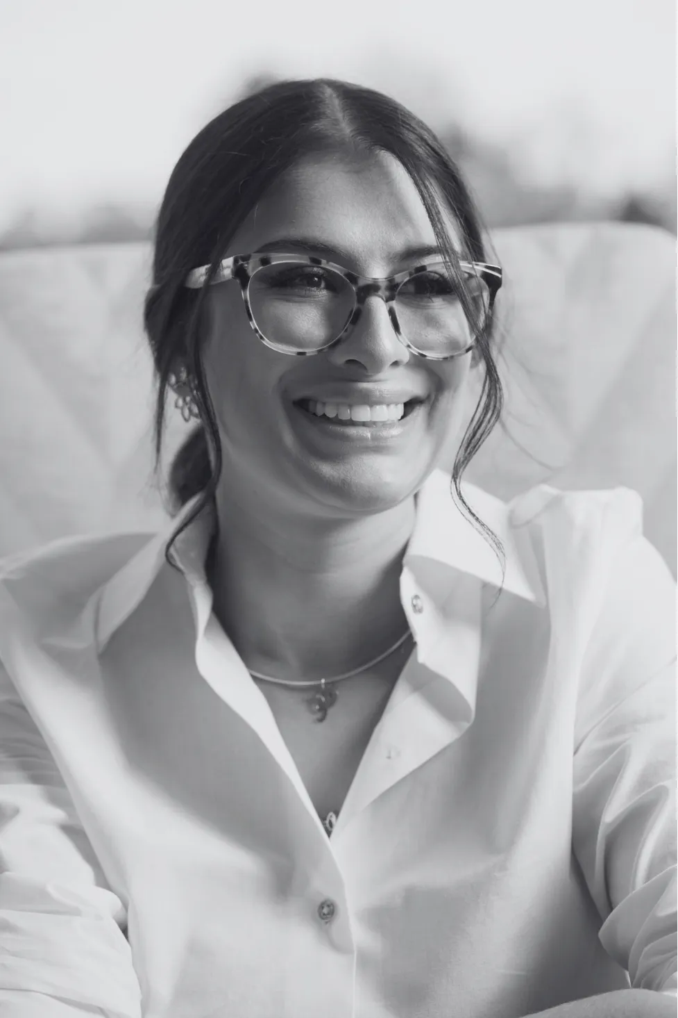 Dra. Priscilla Ruas de óculos, sorrindo